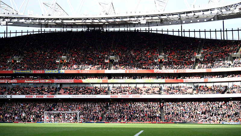 Fullsatt läktare på Emirates Stadium med Arsenal FC fans som ser på Premier League-match. Tar dig till fotbollsresor och fotbollsbiljetter i London, England.   