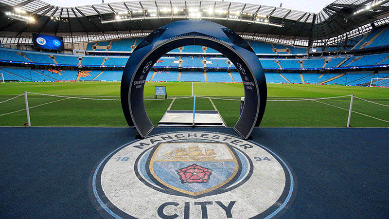 City of Manchester Stadium med Champions League ingång med Manchester City emblem och blåa läktare. Välj fotbollsresor och fotbollsbiljetter till Manchester City matcher i Premier League i England.